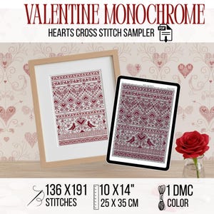 May include: A framed cross-stitch sampler with a Valentine's Day theme. The design features hearts and geometric patterns in shades of red. The text "VALENTINE MONOCHROME" and "HEARTS CROSS STITCH SAMPLER" are visible. The sampler measures 10 x 14 inches.