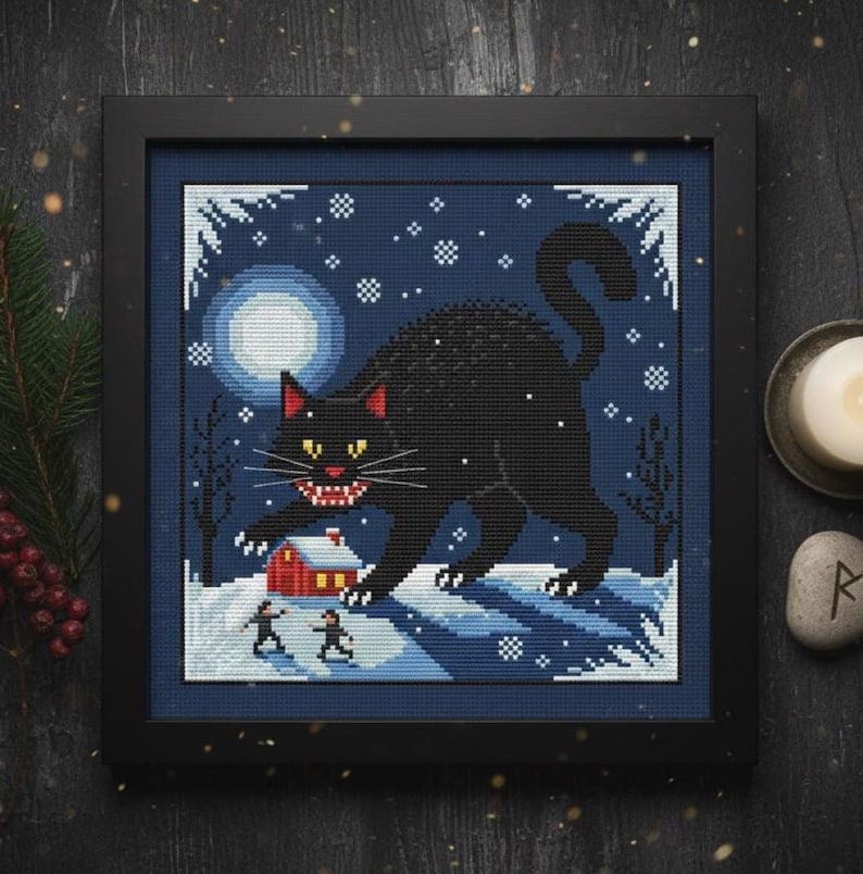 Yule Cat Cross Stitch Pattern Jólakötturinn. Finished cross stitch in a dark frame with festive Norse Christmas decor
