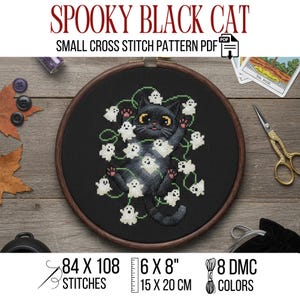 May include: A black cat cross-stitch pattern in a wooden hoop, surrounded by white ghost designs. The text "SPOOKY BLACK CAT" and "SMALL CROSS STITCH PATTERN PDF" are at the top. The pattern size is 6 x 8 inches.