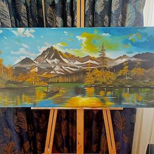 May include: A panoramic oil painting on canvas depicting a serene mountain lake landscape. The scene features snow-capped peaks, golden autumn trees, and a small boat floating on the water, all rendered in vibrant shades of blue, yellow, and brown.
