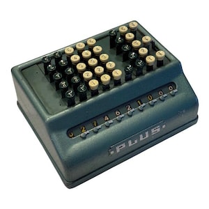 May include: A vintage blue mechanical adding machine with a row of number keys and a display window showing the number 0274621000. The machine is labelled "PLUS."
