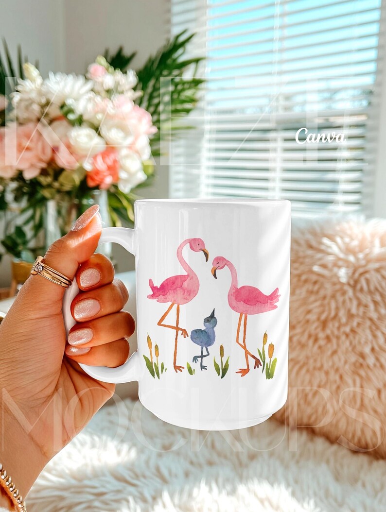 Trendy hand held mug mockup featuring a 15oz ceramic coffee mug with watercolor flamingo artwork example. Styled in a warm lifestyle scene with soft daylight and cozy textures. Fully editable mug body using Canva drag and drop template. High quality mug mockups ideal for artistic, colorful, and modern mug mockup presentations.