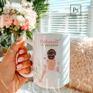 15oz mug mockup displayed as a hand held coffee cup featuring an illustrated artwork example on the mug body. Styled in a warm, trendy interior with soft textures and daylight. Mug mockup supports easy design replacement using PSD smart object and Canva drag and drop template. High quality mugs mockup for branding and gift product listings.