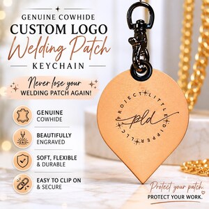 May include: A custom logo welding patch keychain made of genuine cowhide. The light brown leather keychain is engraved with a logo and text, and features a black clip. The text on the keychain says "PROJECT LITTLE DIPPER LLC" and "pld".