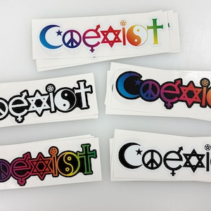 May include: A stack of stickers with the word "Coexist" printed in black and white. The word is surrounded by symbols representing different religions, including a crescent moon, a peace sign, a Star of David, a yin-yang symbol, and a cross. The stickers are on a white background.