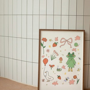 May include: A framed print with a white background and a variety of colorful illustrations, including a frog wearing a green raincoat, a goose holding a red balloon, a pink bow, strawberries, flowers, and a cup of coffee.