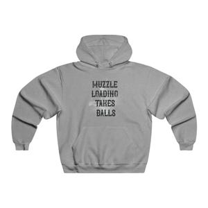 Könnte beinhalten: Hellgrauer Kapuzenpullover mit dem Text "MUZZLE LOADING TAKES BALLS" in schwarzer Used-Schrift. Der Hoodie hat eine Vordertasche und eine Kapuze mit Kordelzug. Hergestellt aus einem weichen, bequemen Material.
