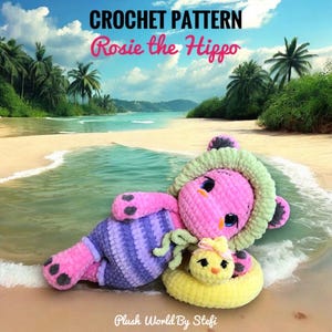 May include: A crocheted plush hippo toy named Rosie, wearing a purple and blue striped outfit and a green hood, is lying on a beach. A yellow duck toy floats nearby. The image includes the text "CROCHET PATTERN Rosie the Hippo" and "Plush World By Stefi".