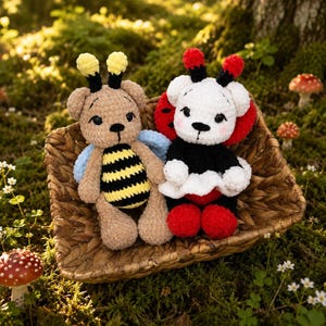 May include: Two handmade crochet teddy bears, one styled as a bee with yellow and black stripes and the other as a ladybug with red and black accents. They sit in a woven basket on a mossy surface, surrounded by greenery and small mushrooms.