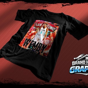 May include: Black t-shirt featuring a graphic of a basketball player with the text "SAN ANTONIO WEMBY" in a distressed style. The shirt has a red and white color scheme and is likely made of cotton.