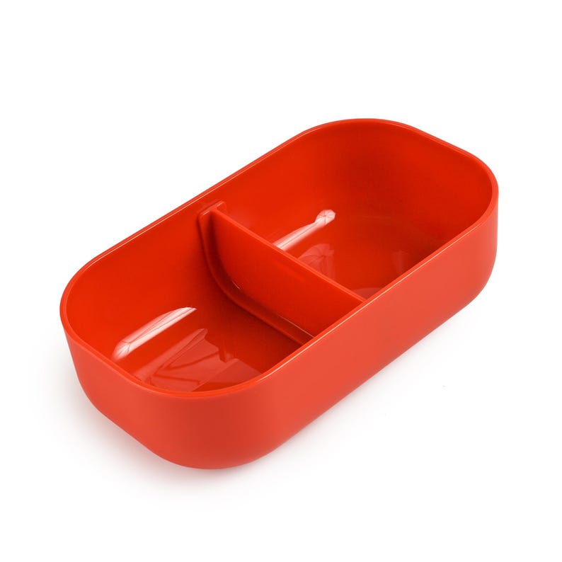May include: A vibrant red food container, rectangular with rounded edges, and a central divider. The container is made of a smooth, solid material, designed to hold two separate food items. The container is empty and sits against a white backdrop.