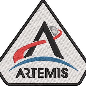 Può includere: Toppa ricamata con il logo Artemis. Il design include una forma a 'A' nera, un elemento curvo rosso, un arco blu e una sfera grigia con un vortice rosso. La parola 'ARTEMIS' è visualizzata in nero, sotto l'arco blu, all'interno di un triangolo bianco.