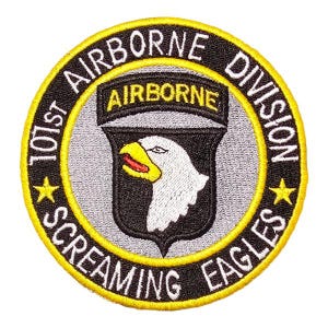 May include: A circular embroidered patch featuring the 101st Airborne Division Screaming Eagles insignia. The design includes a black border with yellow text, a central shield with a white eagle head, and a black tab with the word AIRBORNE.