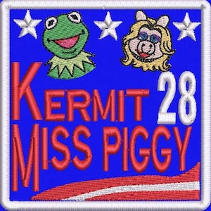 Puede incluir: Parche bordado con la Rana Gustavo y Miss Piggy sobre un fondo azul. El parche incluye el texto "KERMIT MISS PIGGY 28" en rojo y blanco. Un diseño a rayas rojas y blancas en la parte inferior.
