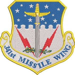 May include: A white ceramic mug with a black handle and the text "But First, Coffee" in a bold, black font. The mug is set against a blurred background, suggesting a cozy setting.