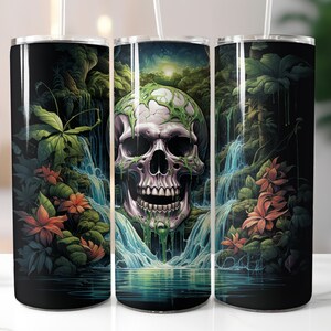 May include: A black tumbler featuring a vibrant illustration of a skull with a waterfall backdrop. The skull is detailed with green vines and surrounded by lush green foliage and orange flowers. A white straw is inserted into the tumbler.