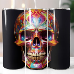 May include: A set of three stainless steel tumblers with a vibrant, colorful skull design. The skull features a psychedelic pattern of swirling blues, yellows, oranges, and purples. The background of the tumblers is black, and each has a white straw.