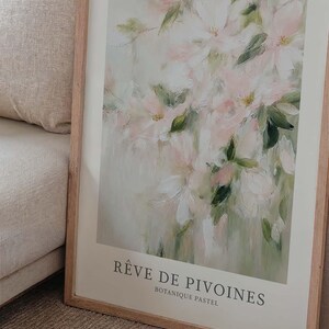 May include: A framed art print featuring a soft, impressionistic floral painting. The artwork showcases delicate pink and white flowers with green leaves against a muted background. The print is titled "R&ecirc;ve de Pivoines" and "Botanique Pastel".