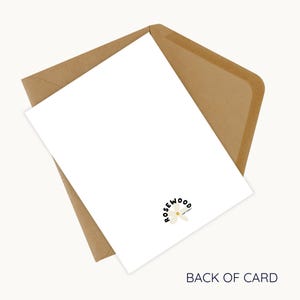 May include: A white card with the text "BACK OF CARD" and a logo that says "rosewood" with a flower design, inside a brown envelope. The card is angled, showing the back of the card.