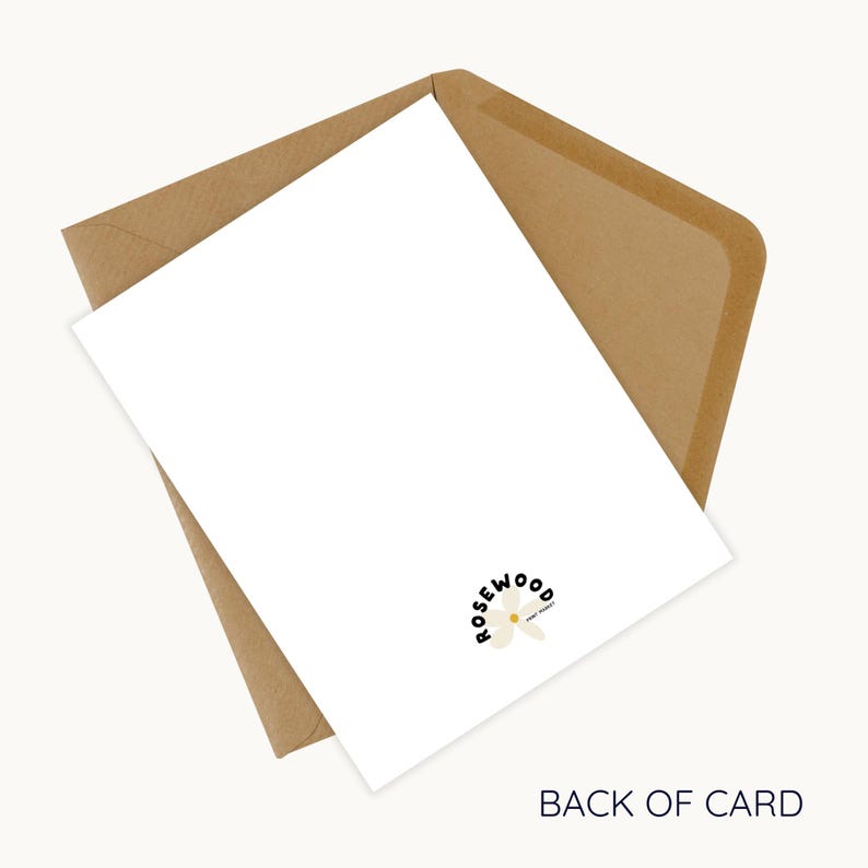 May include: A white card with the text "BACK OF CARD" and a logo that says "rosewood" with a flower design, inside a brown envelope. The card is angled, showing the back of the card.