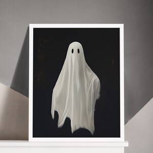 Peut inclure: Une estampe encadr&eacute;e repr&eacute;sentant un fant&ocirc;me blanc avec deux yeux noirs sur un fond noir.