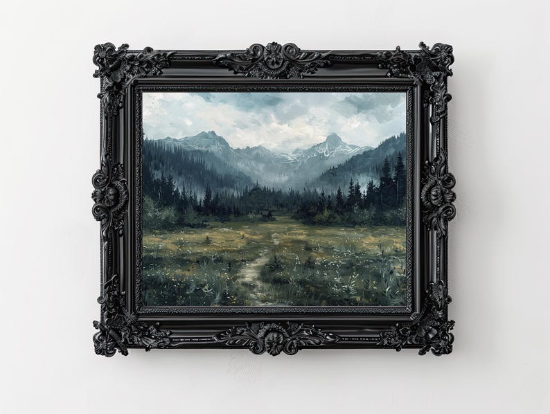 K&ouml;nnte beinhalten: Ein gerahmtes Gem&auml;lde einer nebeligen Berglandschaft mit einem Pfad, der durch ein Feld mit Wildblumen f&uuml;hrt. Die Berge sind dunkelblau-grau, und der Himmel ist hellblau mit wei&szlig;en Wolken. Der Rahmen ist schwarz und verziert.