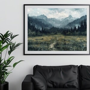 K&ouml;nnte beinhalten: Ein gerahmter Druck einer nebligen Berglandschaft mit einem Pfad, der durch ein Feld mit Wildblumen f&uuml;hrt. Die Berge sind in einem tiefen Blaugrau gehalten, und der Himmel ist hellblau mit wei&szlig;en Wolken. Der Druck ist in einem schwarzen Rahmen.