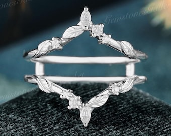 May include: A delicate silver ring enhancer with a leaf design and small round and marquise-shaped diamonds.