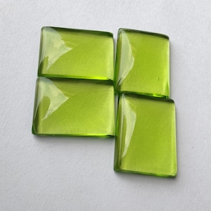 May include: Four square green glass tiles with a smooth, glossy finish.