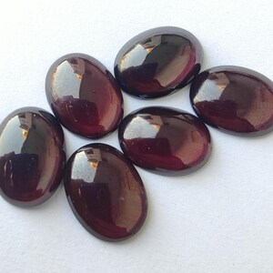 Puede incluir: Seis piedras preciosas ovaladas de color p&uacute;rpura oscuro con un acabado brillante.