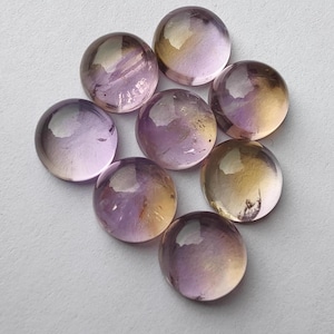 Può includere: Otto pietre preziose rotonde, lisce e a cabochon con un gradiente di colori viola, giallo e arancio.