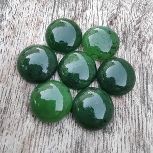 May include: Seven round, green jade cabochons, polished and smooth, with a slight variation in shade and pattern.