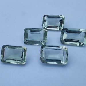 Op de afbeelding: Zes smaragdgroene edelstenen geslepen in een rechthoekige vorm met afgeschuinde randen.