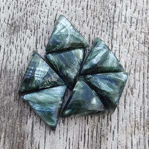 May include: Seven green and black triangular gemstone beads with a marbled pattern.