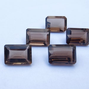 Pode incluir: Seis pedras preciosas de quartzo fumado cortadas em forma de esmeralda. As pedras preciosas são de cor castanho escuro e têm um acabamento liso e polido.