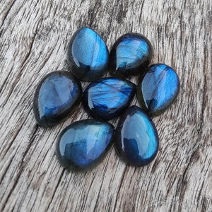 AAA+ labradoritcabochon av naturlig kvalitet: Päronformade, droppformade, kalibrerade ädelstenar med platt baksida. bild 2