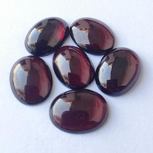 Puede incluir: Seis piedras preciosas ovaladas de color p&uacute;rpura intenso y rico. Las piedras son lisas y pulidas, con un acabado brillante.