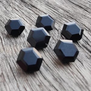 May include: Six black hexagonal-shaped buttons with a glossy finish.