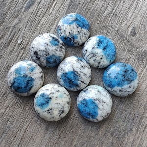 May include: Eight round blue and white cabochon stones. The stones have a marbled pattern with blue and white swirls.