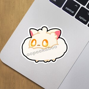 May include: A white fluffy sticker with a cartoon animal with pink ears and yellow eyes. The sticker has the text "oopeekaboo" on it.