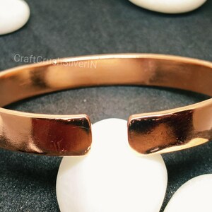 Peut inclure: Un bracelet jonc en cuivre avec une finition lisse et brillante. Le bracelet est ouvert aux deux extr&eacute;mit&eacute;s et pr&eacute;sente une l&eacute;g&egrave;re courbure.