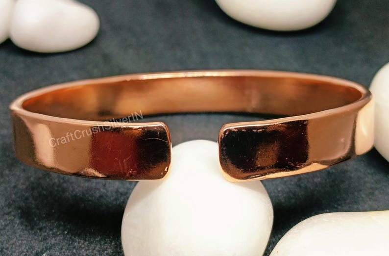 Peut inclure: Un bracelet en cuivre avec un espace sur un c&ocirc;t&eacute;. Le bracelet est brillant et a une surface lisse. Le texte "CraftCrushSilverIN" est visible sur le bracelet.
