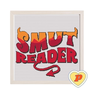 Op de afbeelding: Kruissteekkunst in een licht houten frame. Het ontwerp toont de woorden "SMUT READER" in rood en oranje, met een duivelsstaart. Een hartvormig logo met een "P" staat in de rechter benedenhoek.