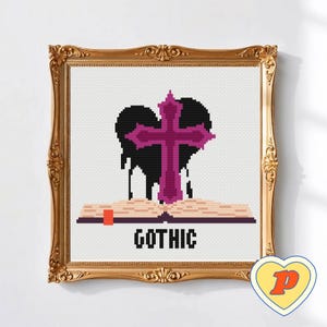 May include: Cross-stitch artwork in a gold ornate frame. The design features a black heart with dripping accents, a purple cross, and an open book with the word "GOTHIC" in white block letters. A yellow heart with a "P" logo is in the bottom right corner.