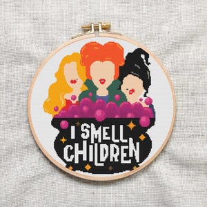 May include: Cross stitch pattern featuring three witches in a cauldron with the text "I smell children".