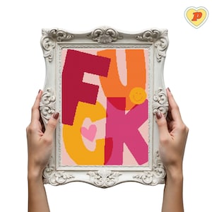Può includere: Un'opera d'arte a punto croce incorniciata con la parola "FUCK" in lettere colorate. Le lettere sono in tonalità di rosso, arancione, giallo e rosa, con un cuore e una faccina sorridente. La cornice è bianca e ornata.