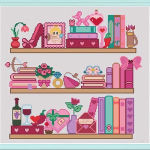 May include: A cross-stitch pattern featuring three shelves filled with various items including books, a cupid picture, a balloon dog, a diamond ring, a wine bottle, a glass, a heart-shaped box, and floral arrangements in shades of pink, red, and teal.