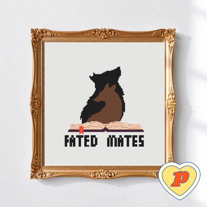 May include: Cross-stitch artwork in a gold ornate frame. The image shows a black and brown wolf-like creature sitting on an open book. The text "FATED MATES" is below the book. A heart-shaped logo is in the bottom right corner.