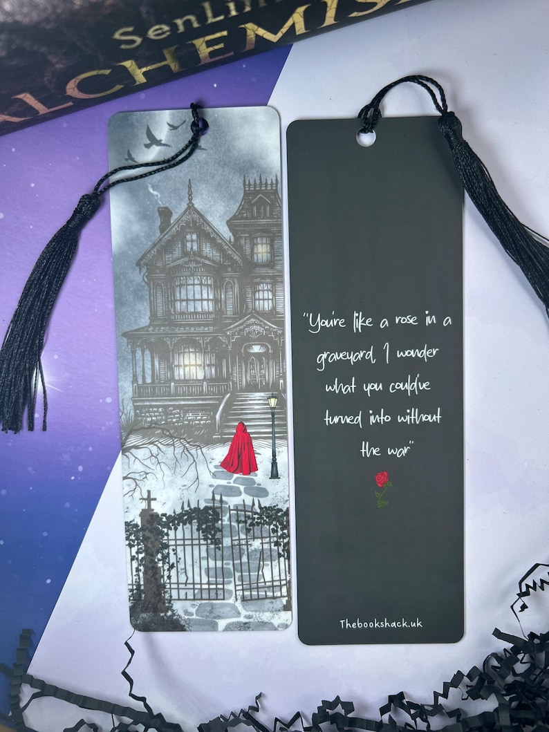 May include: Two bookmarks with black tassels. One features a grayscale illustration of a haunted house and a figure in a red cloak. The other has a quote about a rose and a graveyard, with a rose graphic and the text "Thebookshack.uk".