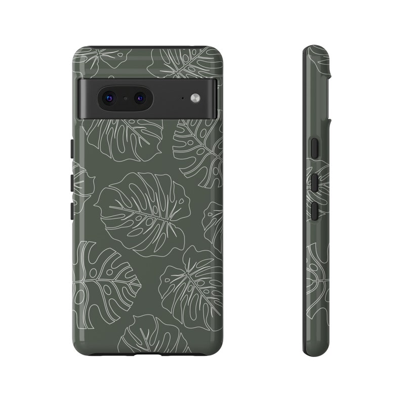 May include: A dark green phone case with a white leaf pattern. The case has a cutout for the camera lens.